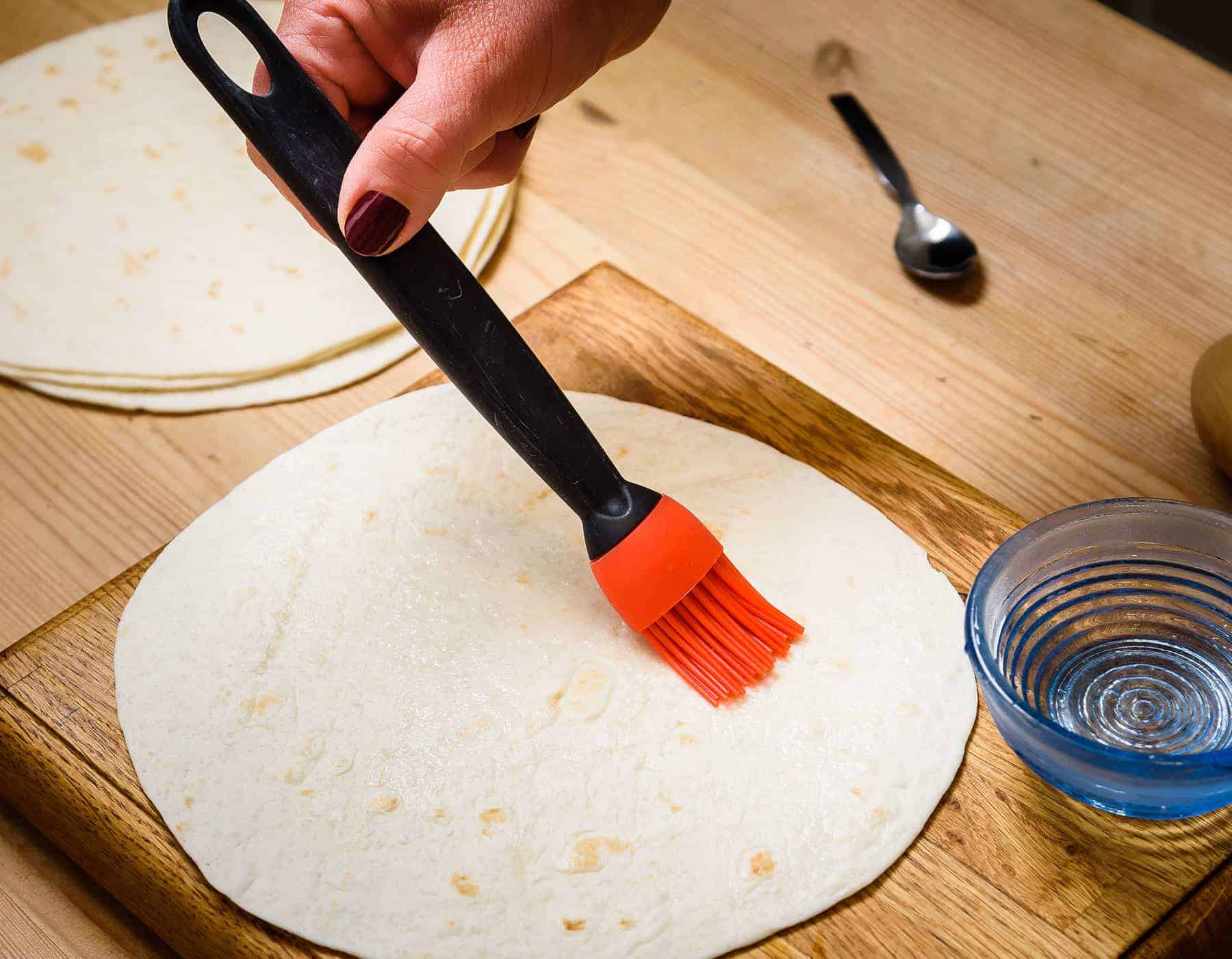 Brushing tortilla with water
