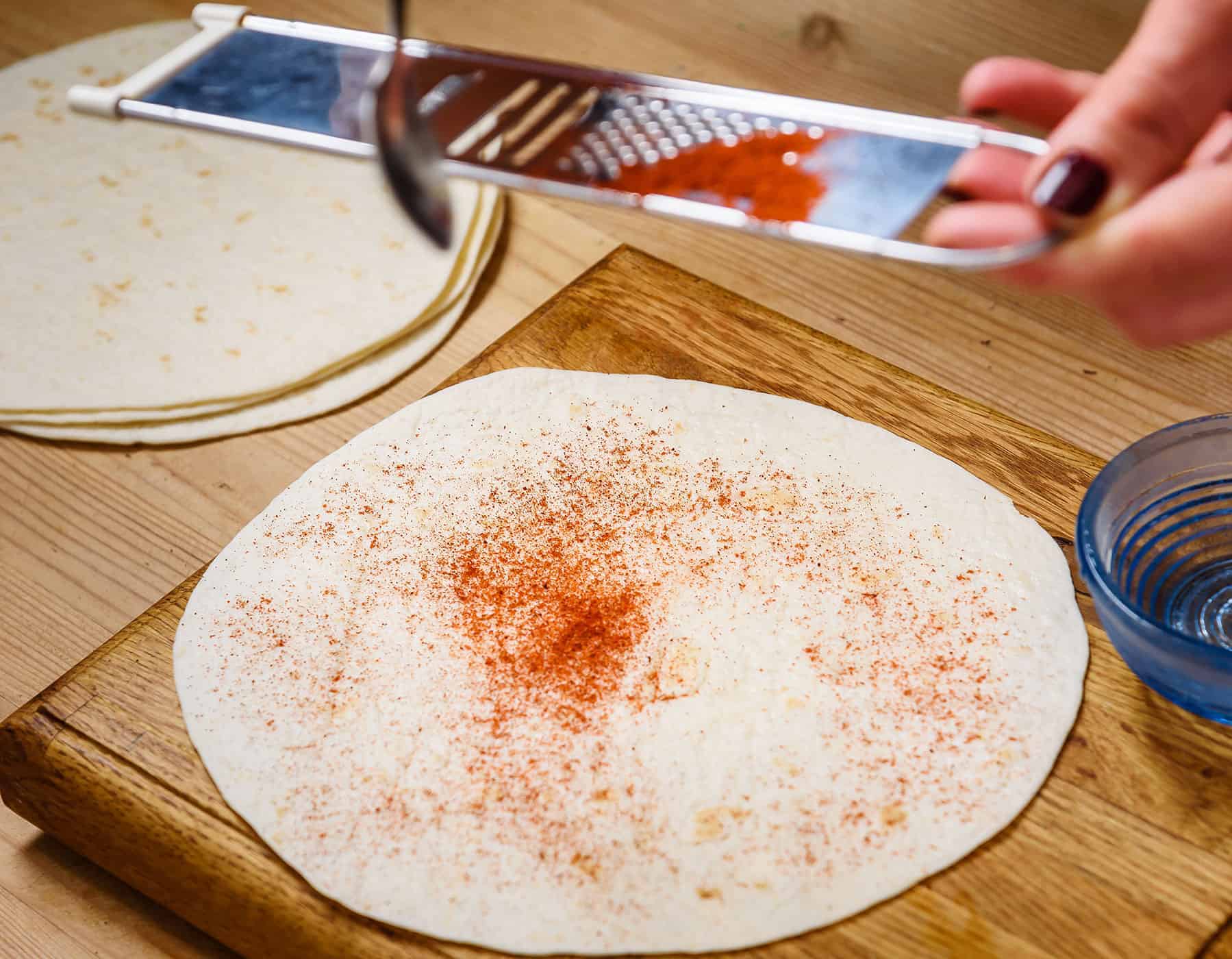 Dusting wet tortilla with smoked paprika