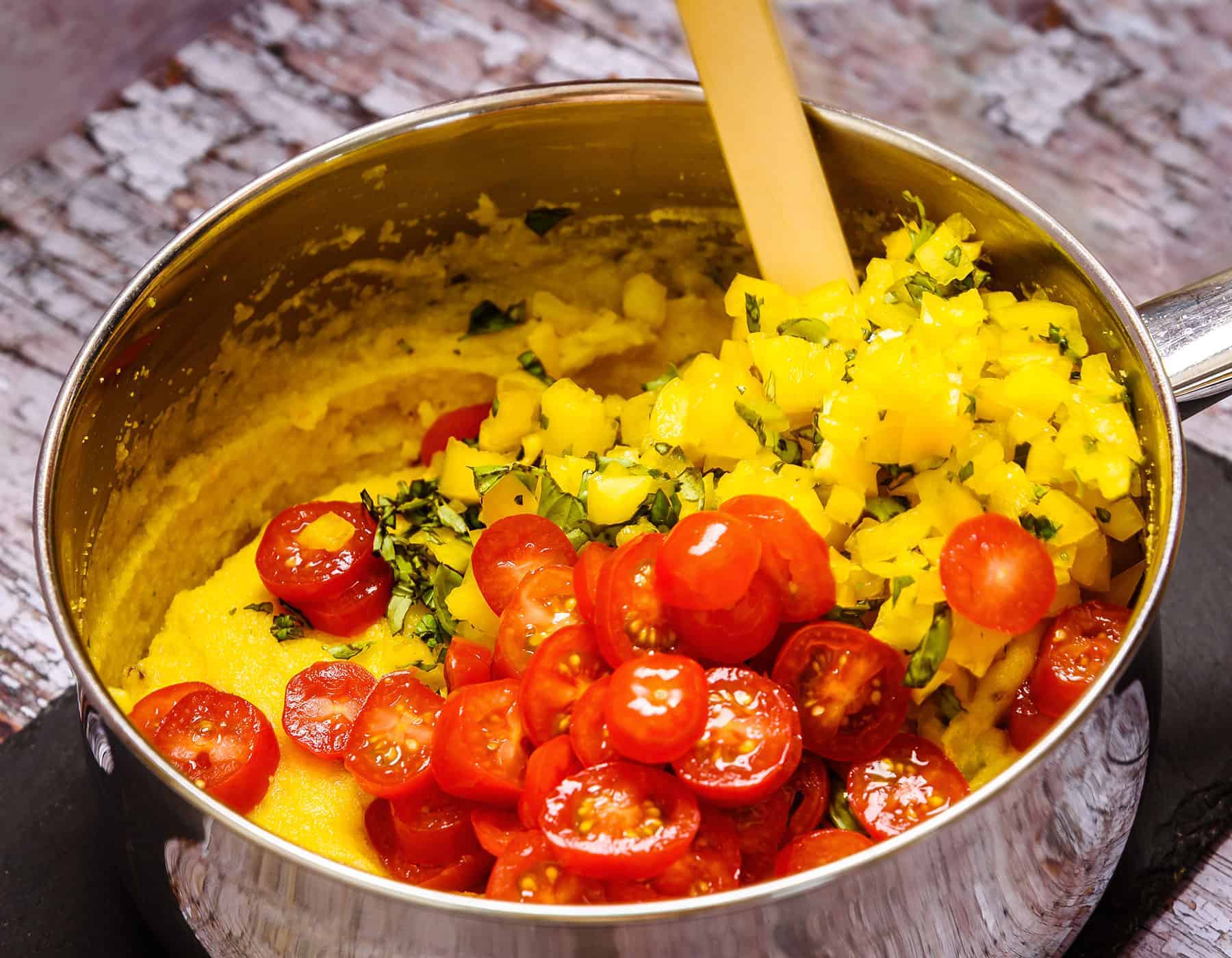 Adding Tomatoes and Yellow Pepper to Polenta Mixture