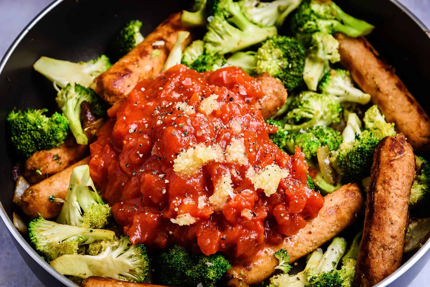 Adding chopped tomatoes and garlic to the pan