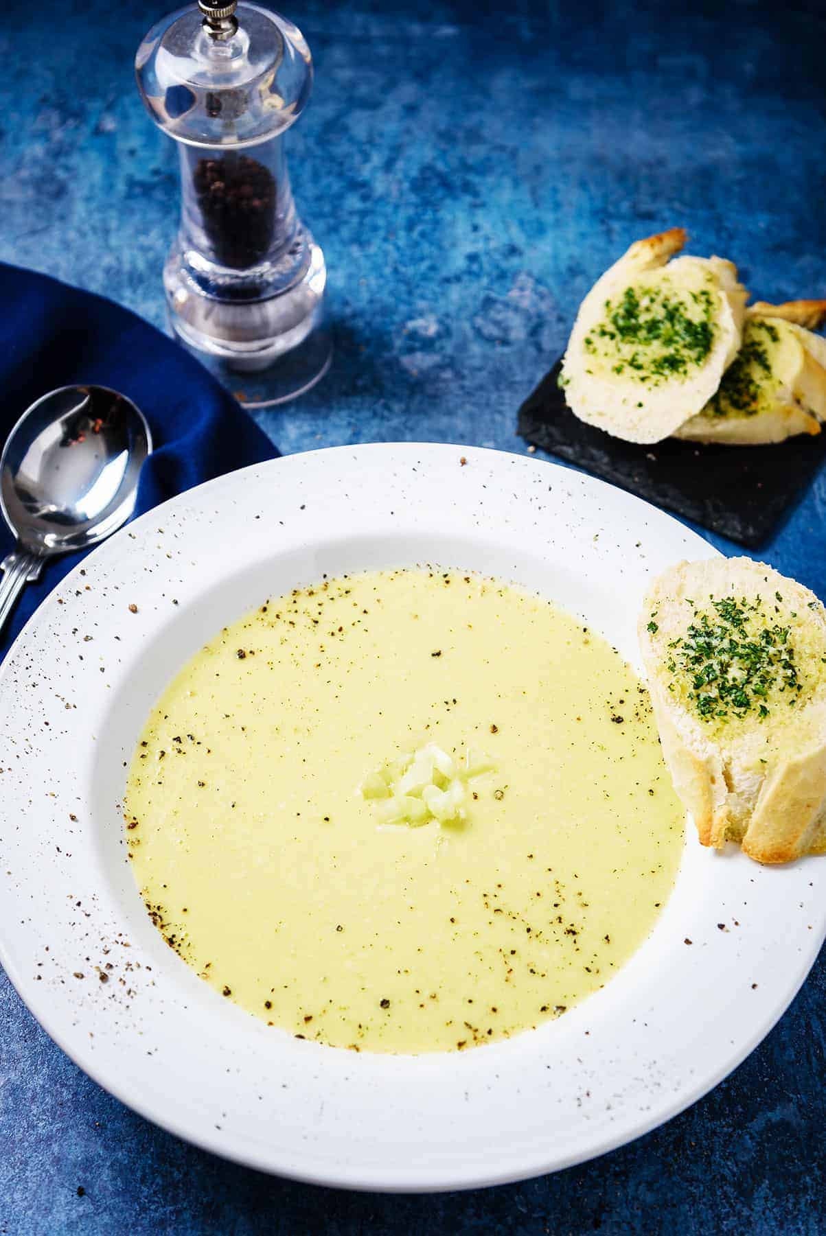 Creamy Vegan Celery Soup in a Serving Bowl with Garlic Bread