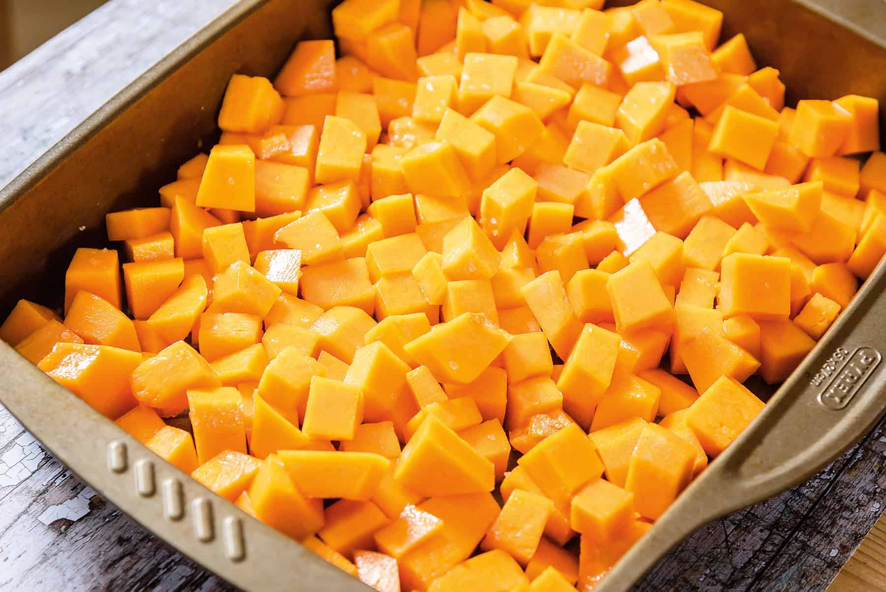 Diced butternut squash in oven tray