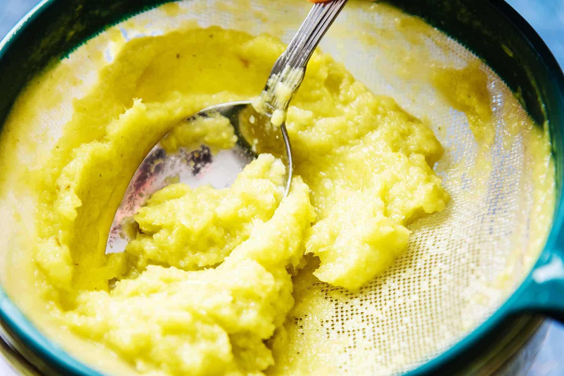 Pushing the celery through a fine sieve