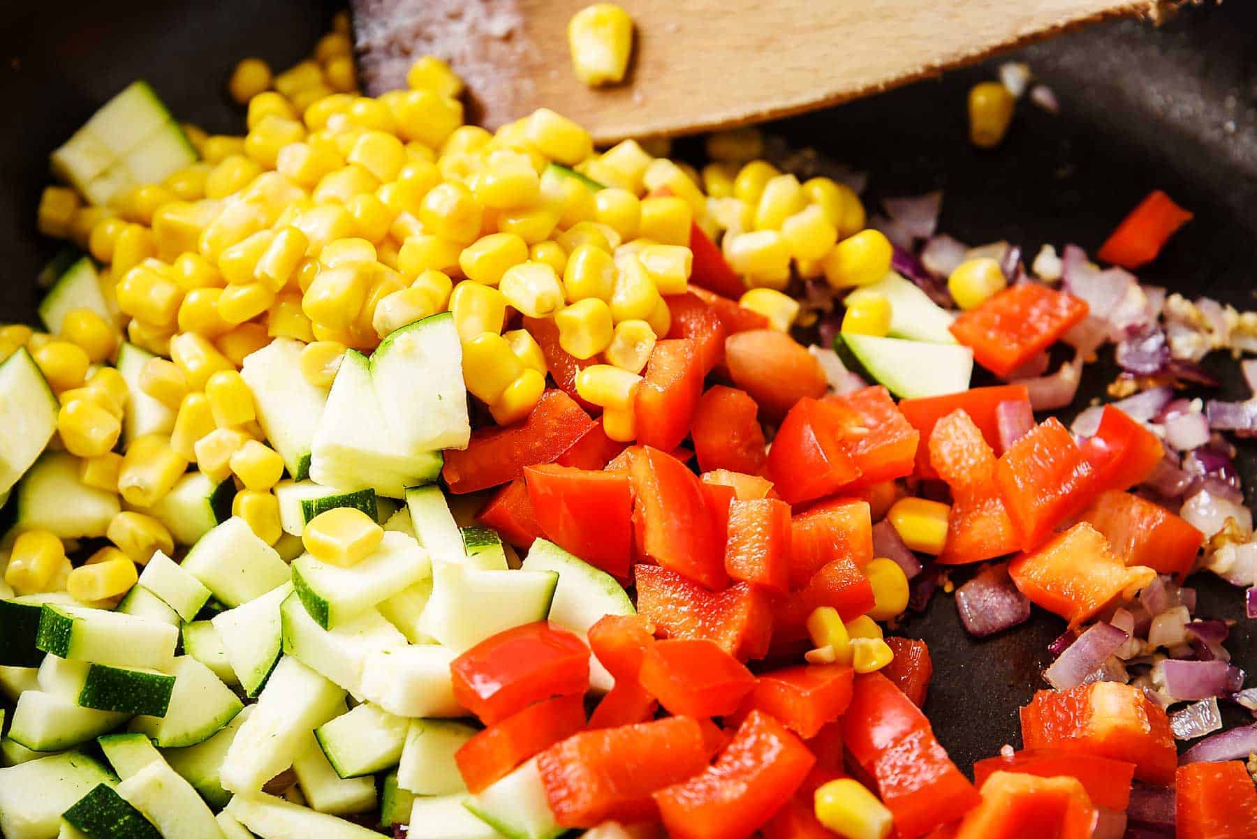Adding chopped vegetables to the pan