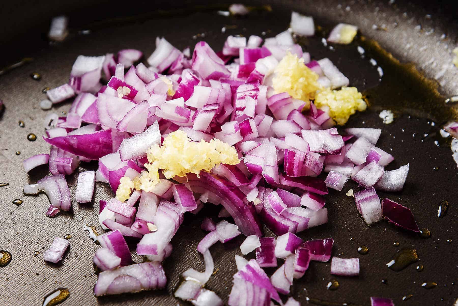 Adding onion and garlic to the pan