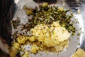 Vegan butter with garlic puree and chopped rosemary in a bowl