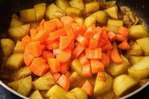 Adding the carrots to the pan