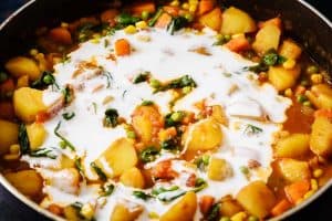 Adding the coconut milk to the cooked curry