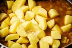 Adding the potatoes to the pan