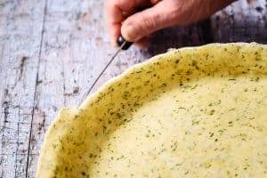 Cutting excess pastry dough from around quiche dish