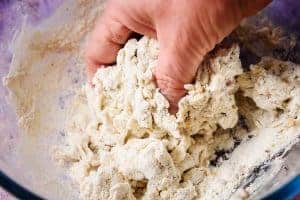 Hand bringing the dough together