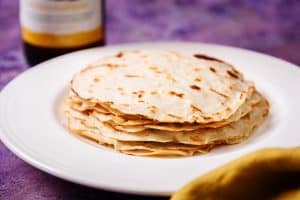 Stack of cooked crepes on a plate