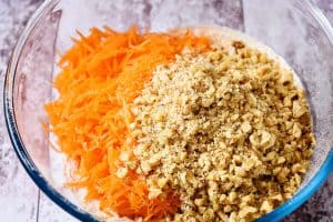 Adding the carrot and walnut pieces to the sieved flour