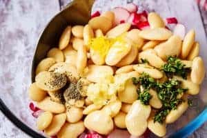 Adding the remaining ingredients to the radish in a bowl