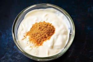 Cajun seasoning added to yoghurt in a bowl