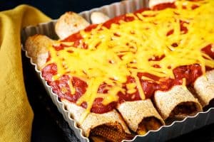 Close up of Vegan Vegetable & Bean Enchiladas in an oven dish