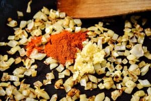 Minced garlic and paprika on cooked onions in a pan