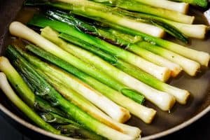 Leeks in a frying pan with stock added
