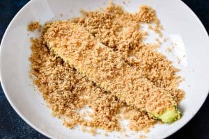 Coating the sliced courgettes with breadcrumbs