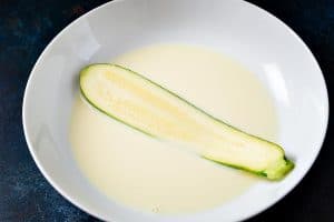 Dipping the sliced courgettes in the milk