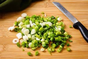 Sliced spring onions on a chopping board