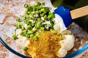Yoghurt, onions and curry powder in a bowl